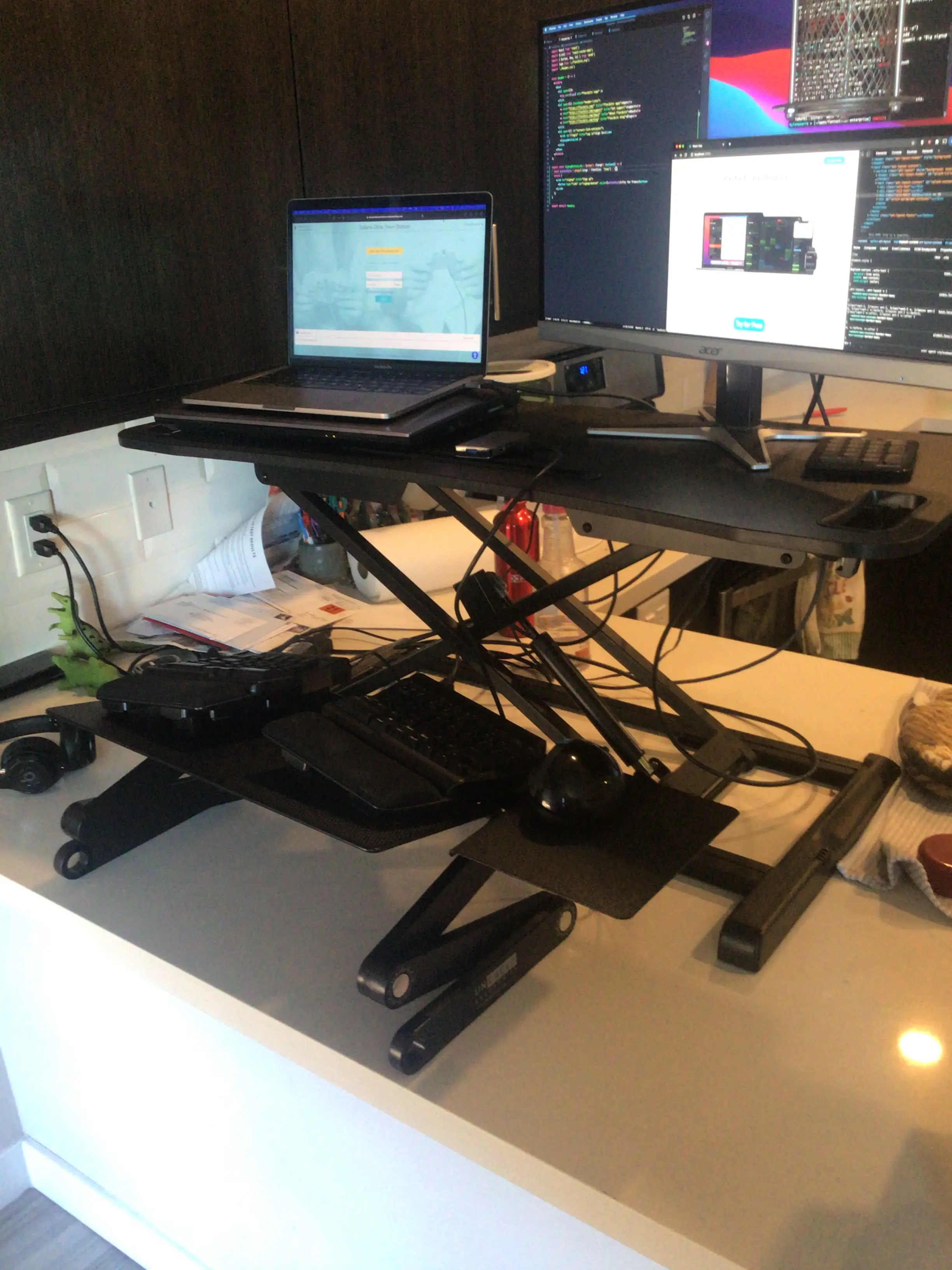 A standing desk with a laptop and external monitor on a kitchen counter
