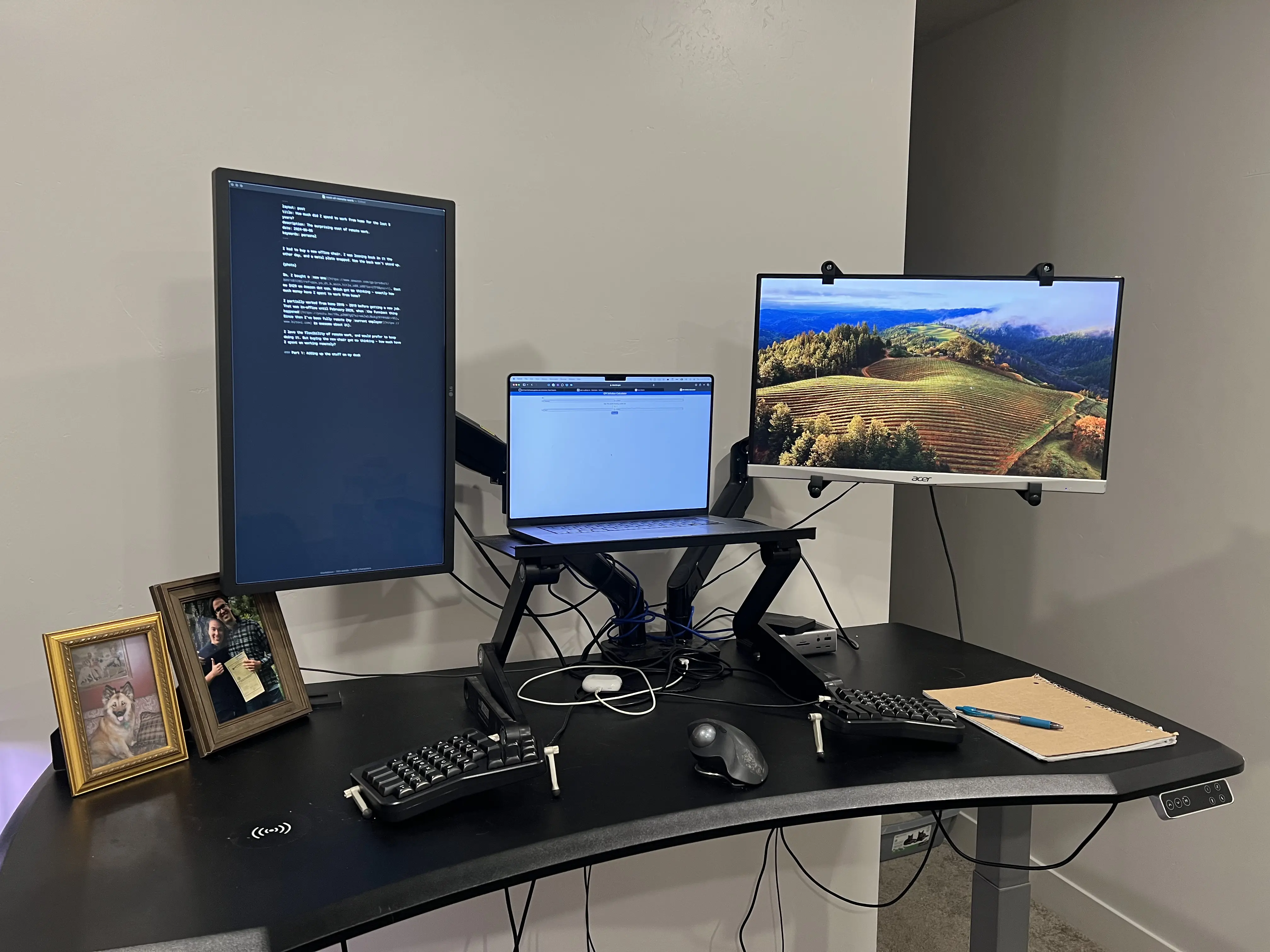 A standing desk with a laptop and two external monitors
